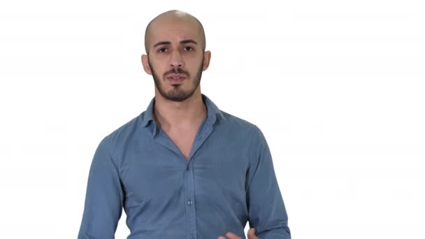 Arabisch lässiger Mann, der vor der Kamera auf weißem Hintergrund läuft und spricht. — Stockvideo