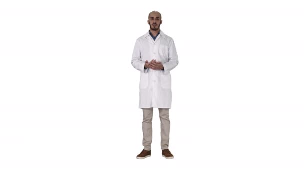 Άραβας γιατρός άνθρωπος σε ιατρική παλτό μιλώντας και παρουσιάζοντας με το χέρι κάτι σε λευκό φόντο. — Αρχείο Βίντεο