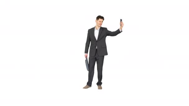 Young businessman taking selfie with his phone on white background. — Stock Video