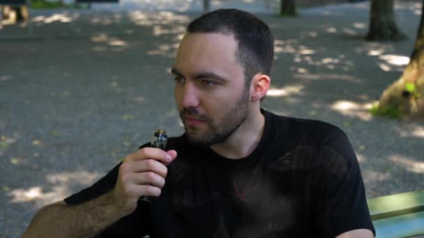 Hombre fumando el vapor al aire libre . — Vídeos de Stock