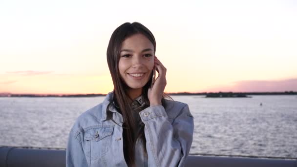 Atractiva chica feliz con sonrisa encantadora haciendo una llamada con teléfono móvil. — Vídeos de Stock