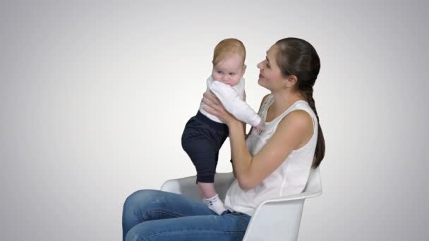 Moeder en schattige baby zittend op een stoel, alfakanaal — Stockvideo