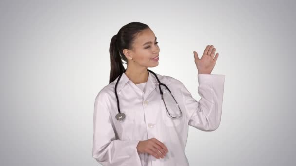 Médica mostrando algo com as mãos estendidas Apresentação em fundo gradiente. — Vídeo de Stock