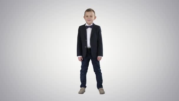 Sonriente niño con ropa formal de pie sobre fondo degradado . — Vídeos de Stock