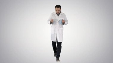 Yürüyen yakışıklı doktor, arka planda maske ve şapka takıyor..