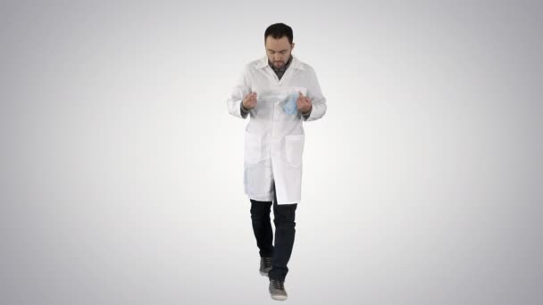 Caminante guapo doctor usando máscara y gorra en gradiente fondo. — Vídeo de stock