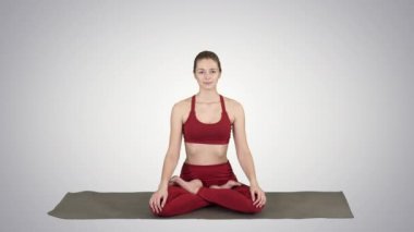 Sportif çekici kadın yoga yapıyor, Lotus egzersizi yapıyor, Siddhasana arka planda nefes alıyor..
