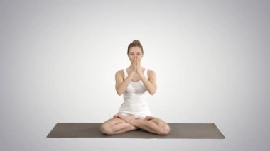 Yoga pozisyonunda rahat kadın birlikte elleri koyarak ve degrade arka plan üzerinde meditasyon.