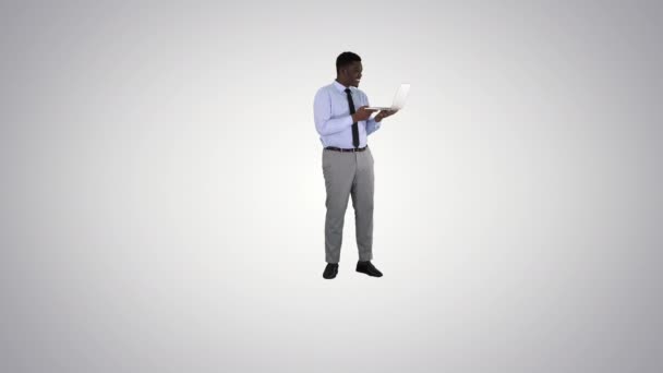 Cheerful successful young African American manager with laptop having video conference call with business partners on gradient background. — Stock Video