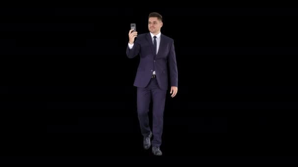 Joven hombre de negocios que utiliza el teléfono inteligente para videocall a su socio de negocios mientras camina, Alpha Channel — Vídeo de stock