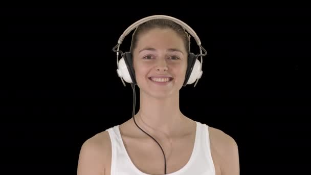 Conceito de música, pessoas e tecnologia - mulher sorridente feliz com fones de ouvido andando, Alpha Channel — Vídeo de Stock