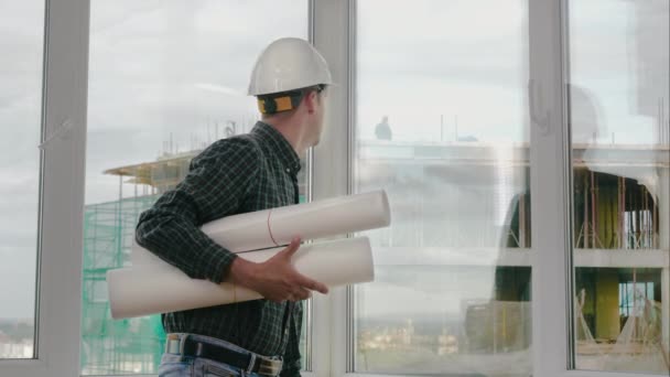 Ingeniero comprobando la construcción a través de la ventana. — Vídeo de stock