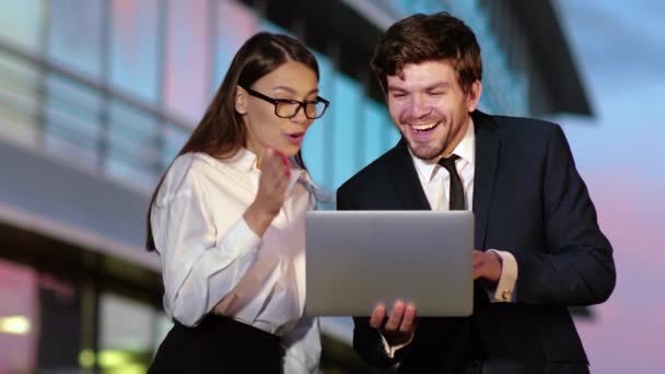 Emocionado casal de negócios recebendo boas notícias no laptop . — Vídeo de Stock