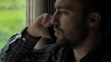 İş adamı trende telefonla konuşuyor..