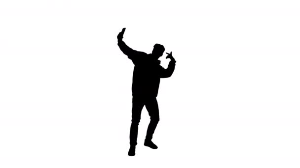 Silhouette збуджений випадковий чоловік танцює і робить селфі зі своїм телефоном . — стокове відео