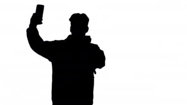 Siluet Heyecanlı rahat adam dans ve telefonu ile selfie yapma.