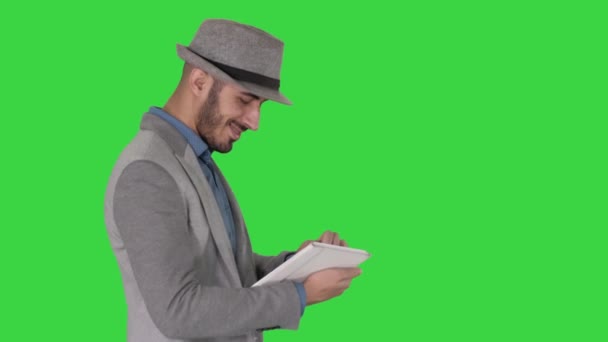 Homem casual usando tablet e sorrindo enquanto acorda em uma tela verde, Chroma Key . — Vídeo de Stock