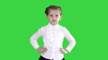 Küçük sevimli kız Yeşil Ekranda kalçalarında elleri ile yürüyüş, Chroma Anahtar.