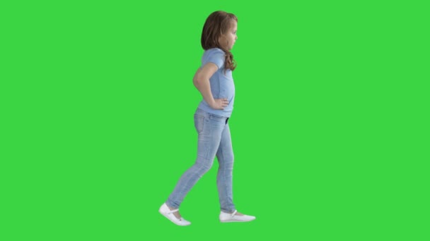 グリーンスクリーン、クロマキーの上を歩くカジュアルな服を着た小さな女の子. — ストック動画