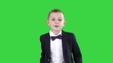 Takım elbiseli çocuk sizi selamlarken Yeşil Ekranda içeri ve dışarı yürüyor, Chroma Key.