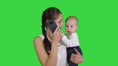 Annelik, çoklu görev, aile ve insan kavramı - yeşil ekranda akıllı telefon arama bebek ile mutlu anne, Chroma Key.