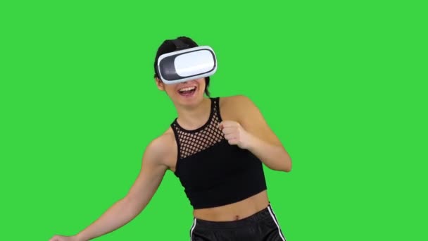 Ευτυχισμένο χαμογελαστή νεαρή κοπέλα χρησιμοποιώντας VR γυαλιά κεφαλής παίζοντας χορεύοντας παιχνίδι πρώτη φορά σε μια πράσινη οθόνη, πλήκτρο αποχρώσεων. — Αρχείο Βίντεο