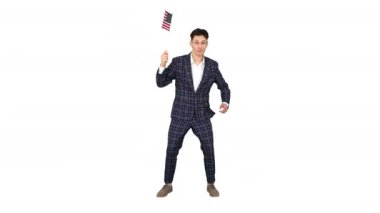 Beyaz arka planda Amerikan bayrağı ile komik bir şekilde dans resmi takım elbiseli genç adam.