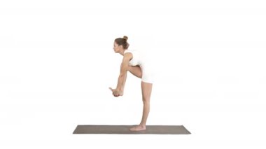 Spor salonunda spor yapan güzel, formda bir kadın Utthita Hasta Padangusthasana, Dandayamana-Janushirasana, Knee Bikram duruşu beyaz arka planda ayakta duruyor.