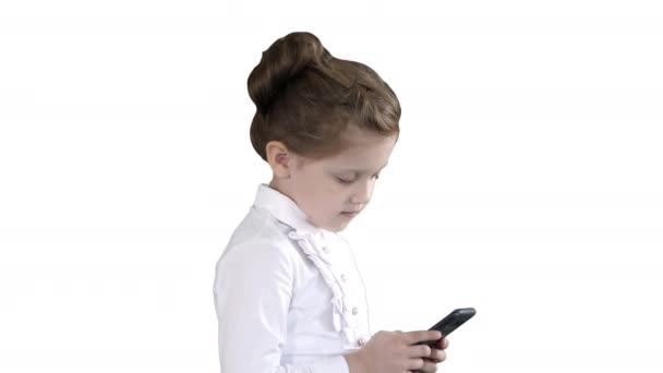 Petite fille utilisant un téléphone intelligent cellulaire sur fond blanc . — Video