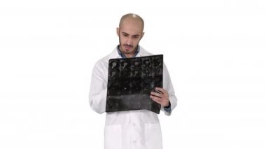 Doktor, beyaz arkaplanda yürürken omuz röntgeni taraması yapıyor..