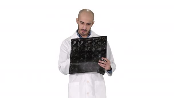 Doctor reviewing shoulder x-ray scan while walking on white background. — Stock Video