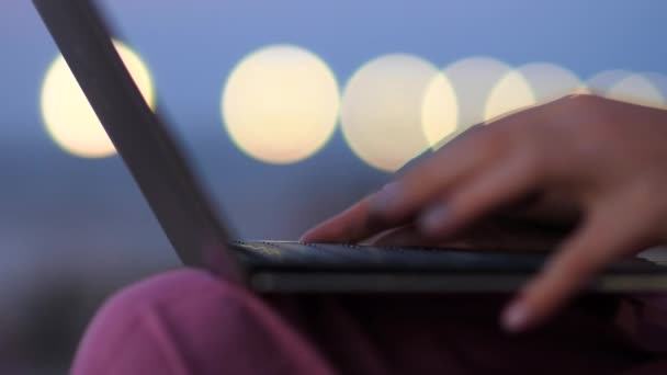 Mujer escribiendo en el ordenador portátil al aire libre tarde en la noche . — Vídeos de Stock