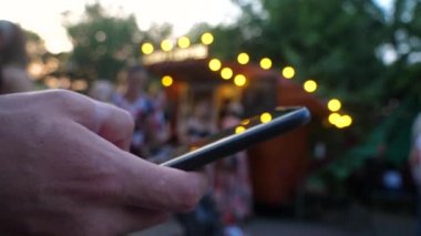 Şehir festivalinde cep telefonu kullanan erkek eli.