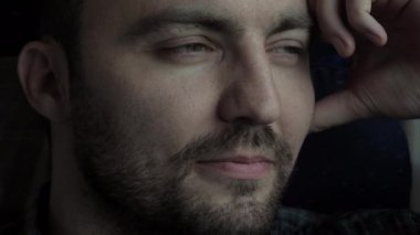 Trenle gidip gelirken pencereden bakan genç adamın yüzü.