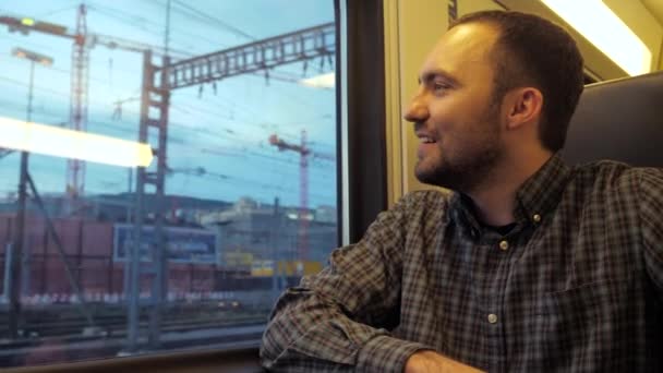 Pasajero alegre mirando por la ventana del tren mientras se mueve rápido. — Vídeo de stock