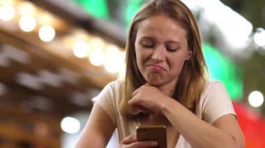 Akıllı telefona bakan hayal kırıklığına uğramış bir kadın. Sinyal ya da aldatmaca mesajı yüzünden hayal kırıklığına uğramış, kötü haberlerden hayal kırıklığına uğramış bir kadın. Üzgün bir kız ya da cep telefonundan reddedilmiş bir kız..