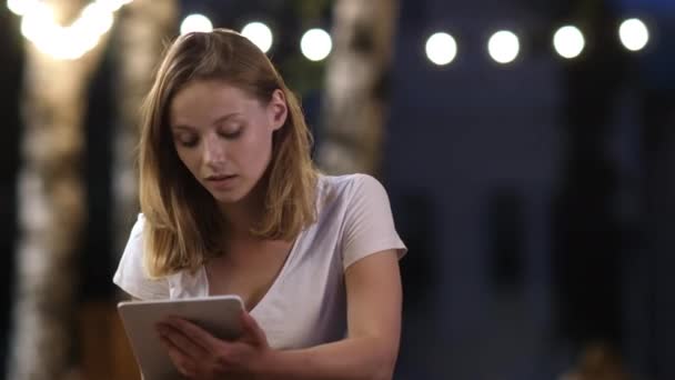 Gadis remaja menggunakan tablet duduk di kafe luar ruangan . — Stok Video