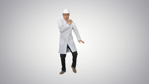 有趣的科学主义者在白色长袍和安全头盔跳舞的梯度背景. — 图库视频影像