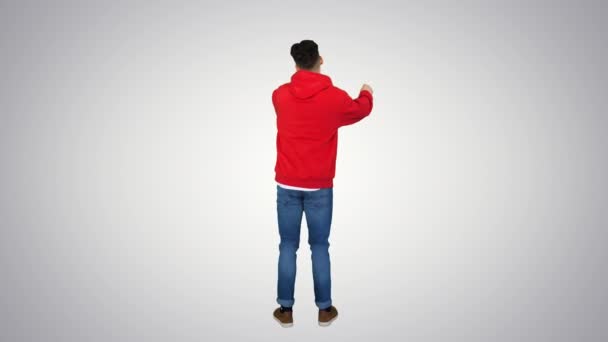 Casual homem dançando em um capuz vermelho no fundo gradiente . — Vídeo de Stock