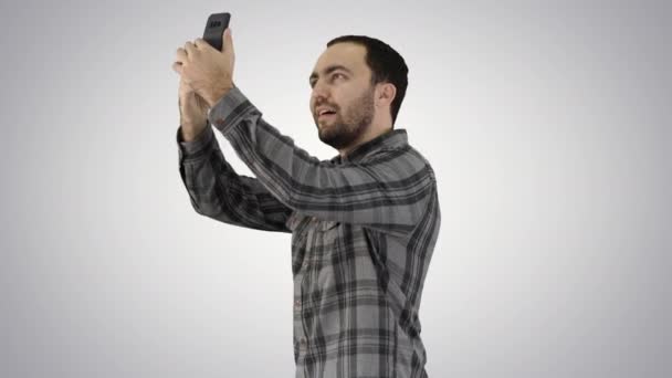 Jonge man het nemen van een selfie op gradiënt achtergrond. — Stockvideo