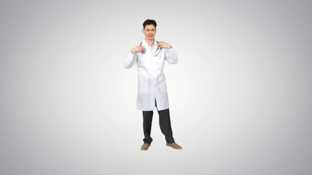 Handsome medical doctor dancing and having fun on gradient background. — Stock Video