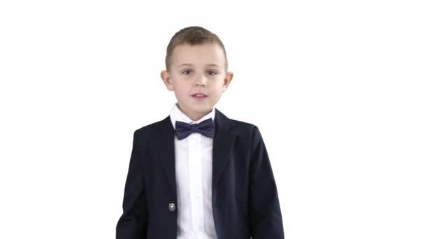 Vänlig liten pojke i kostym säger hej och sedan säger hej då på vit bakgrund. — Stockvideo