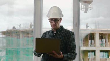 Yakışıklı erkek mühendis iş için bir defter kullanıyor..