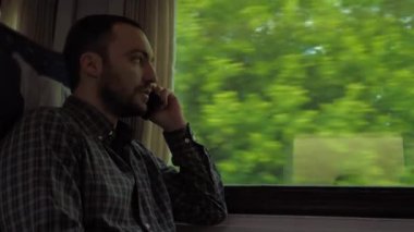 Trende cep telefonuyla konuşan adam.