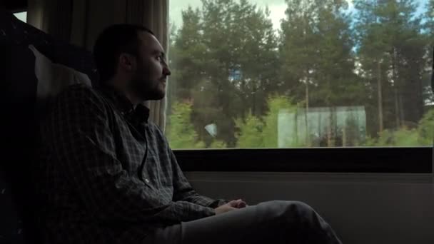 Smutný mladý muž se dívá oknem