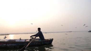 Varanasi, Hindistan - 18 Aralık 2017: Kayıkçı ve martılar.