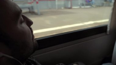 Uzun bir yol. Trende uyuyan adam. Pencerenin arkasında duran insanlar.