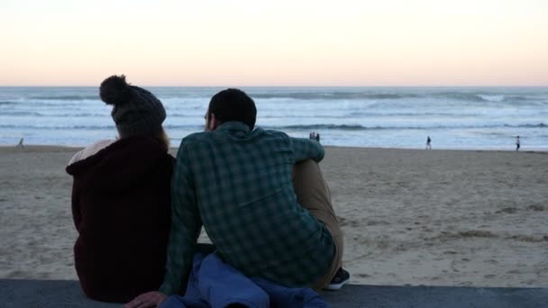 San Sebastian, Spanien-30 december 2017: par sitter på stenmuren beundra havet. — Stockvideo