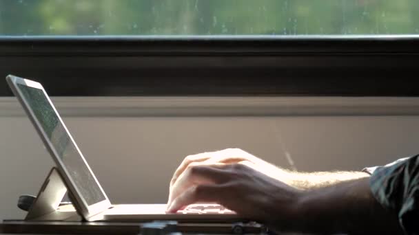 Mans mano digitando sul computer portatile in un treno. — Video Stock