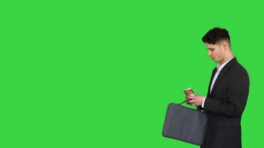 Genç bir iş adamı yeşil ekranda euro banknotlarını sayarak yürüyor, Chroma Key.